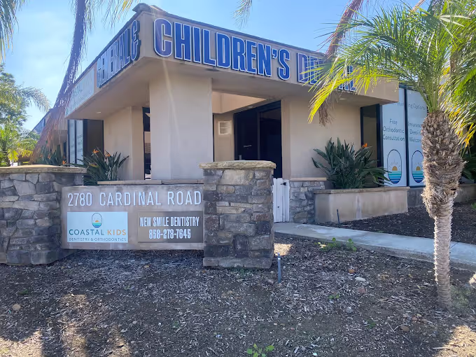 Building with signage for Children's Dentistry located at 2780 Cardinal Road, featuring Coastal Kids Dentistry & Orthodontics and New Smile Dentistry contact details.